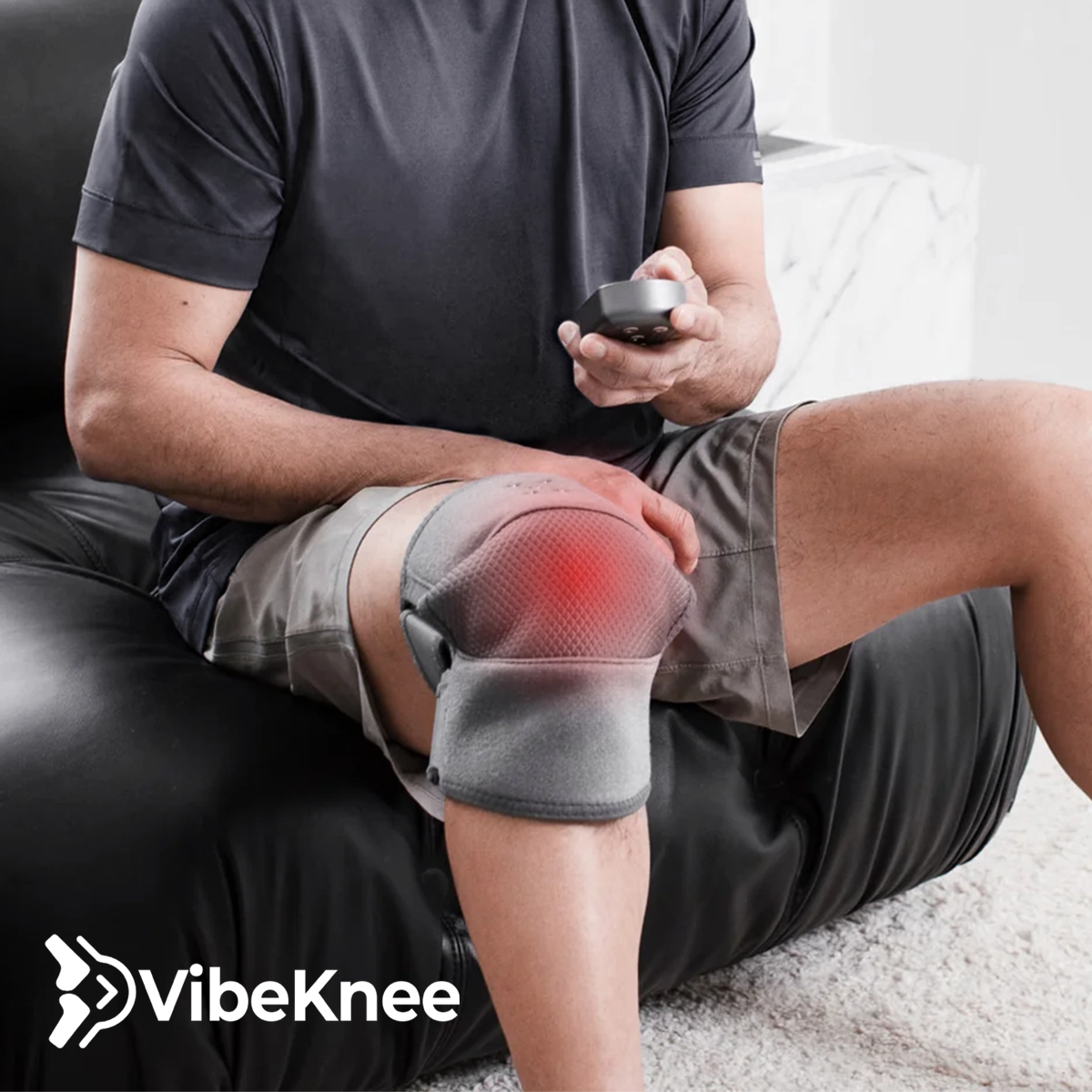 Person using a VibeKnee device on their knee with a focus on comfort and technology.