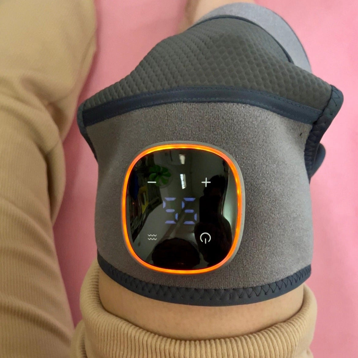 Gray vibeknee brace with digital display on a pink background